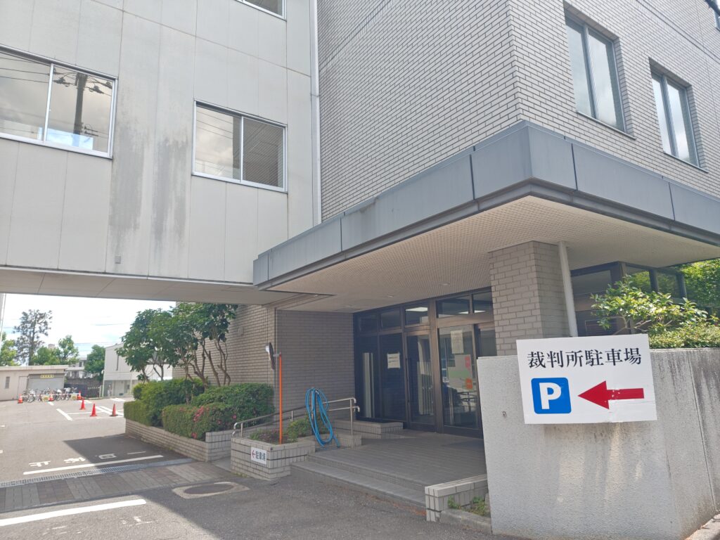 郡山簡易裁判所の敷地内にある裁判所駐車場の案内看板と庁舎入口の様子